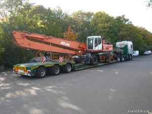 низкорамный прицеп на котором стоит погрузчик ATLAS eurogus